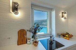 Eine Küche mit Meerblick, ein Holzschnittbrett, eine Schüssel und ein Herd.