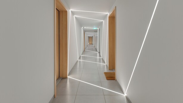 A modern hallway with geometric light patterns, wooden doors, and a tiled floor. - Żeromskiego 23 by Grand Apartments (Gdynia)
