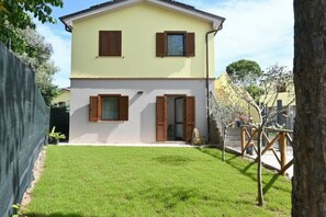 Une maison à deux étages avec une pelouse bien entretenue et une clôture.