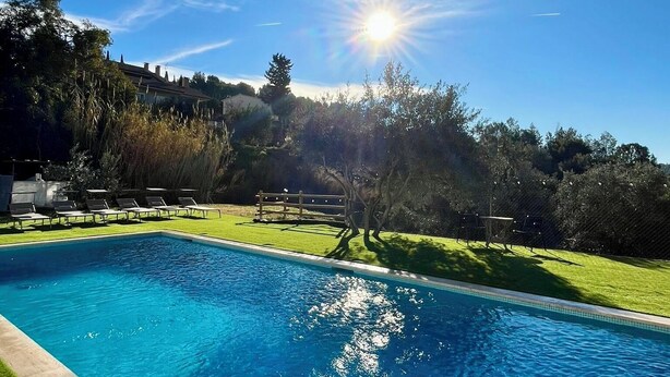 Ein klares, blaues Schwimmbecken mit strahlender Sonne am Himmel.
