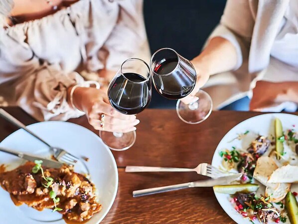 A dining table with two wine glasses, a plate with food, and a fork.