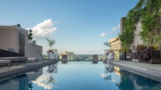 A rooftop pool with clear skies, a view of the city, and modern architecture. - Near Liberty Bell | Rooftop Views + Full Kitchens (Philadelphia)