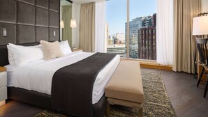 Une chambre d’hôtel moderne avec un grand lit, une vue sur la ville et une grande fenêtre.