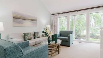 A living room with a sofa, armchair, and a coffee table.