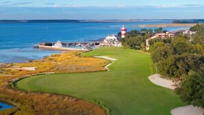A coastal golf course with a lighthouse, water, and buildings. - Near the Beach | 3 Pools + Hot Tub & Full Kitchen (Hilton Head Island)