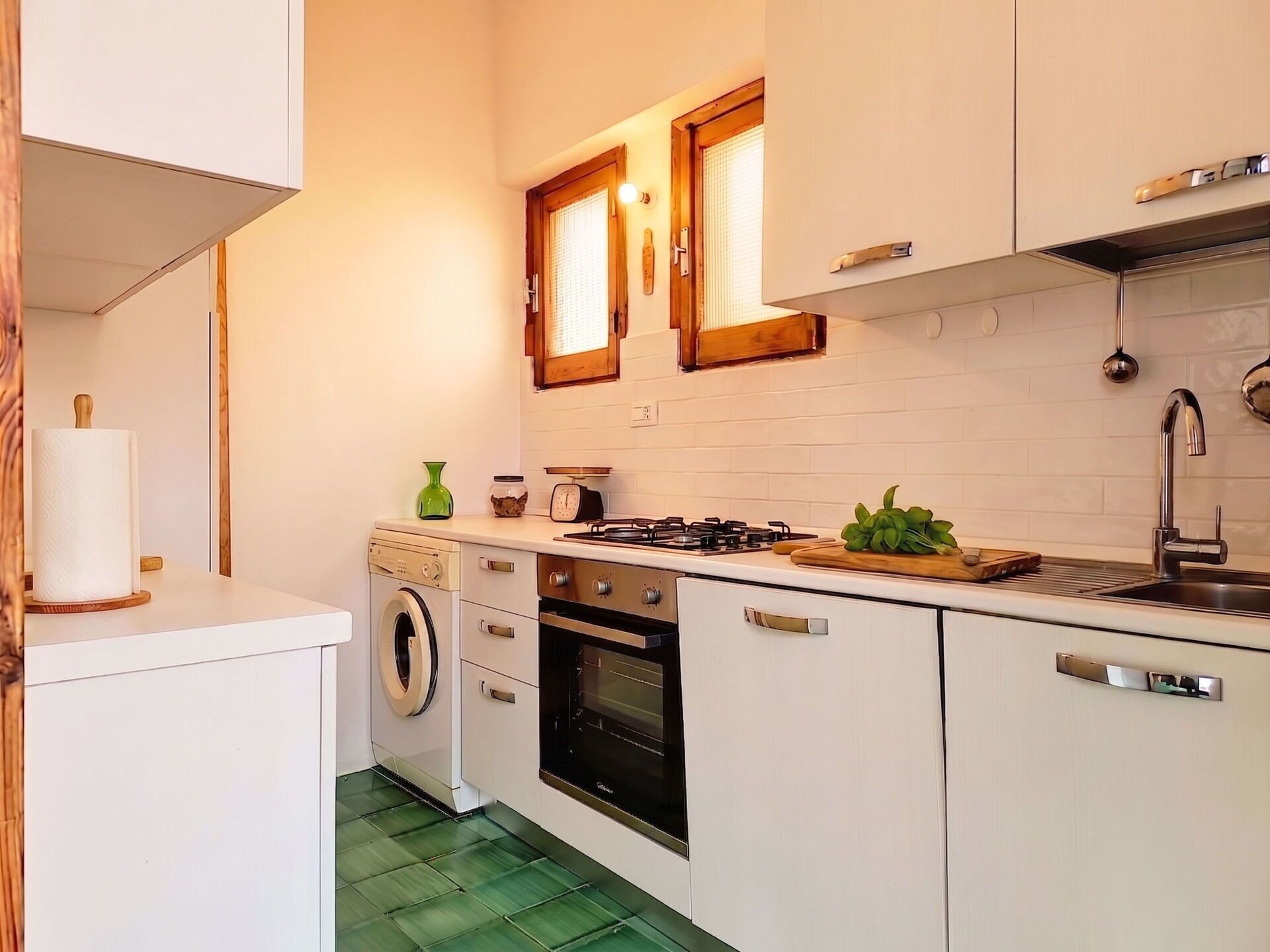 Une cuisine compacte équipée d’un lave-linge, d’un four et d’une cuisinière.
