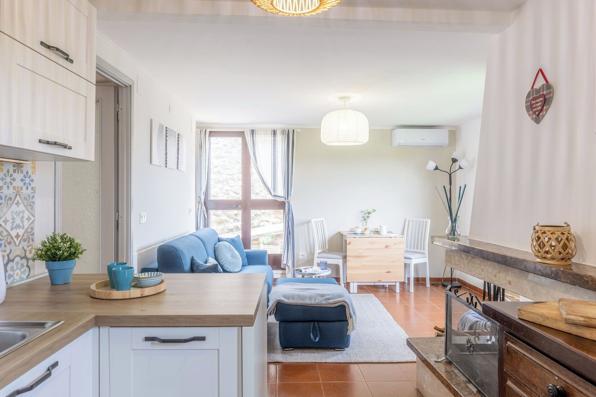 Una cocina moderna con comedor, un sofá y una pequeña mesa.