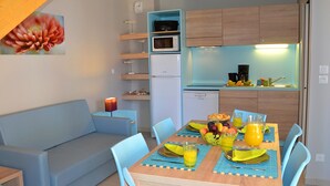 A compact living space with a kitchenette, dining area, and a sofa. - Stunning Holiday Home for 6 in Marseillan (Marseillan)