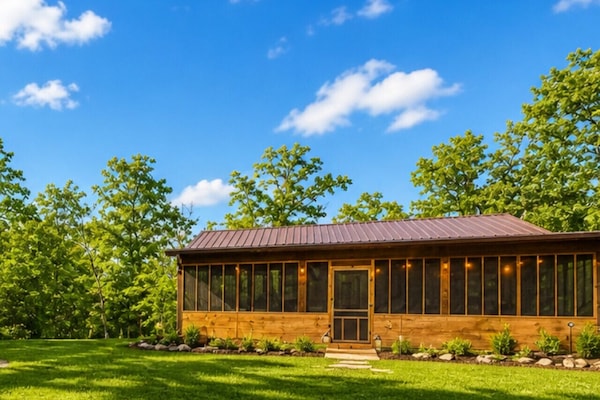 Charming modern rustic cabin with screened-in porch, nestled in lush greenery—perfect private retreat for nature lovers seeking tranquility and outdoor living.