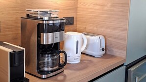 A modern kitchen with a coffee maker, toaster, and kettle on the counter. - Villa Colline St martin - Cap Agde (Agde)