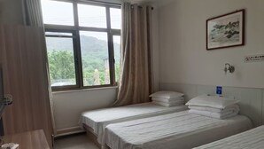 A hotel room with two beds, a desk, a window with curtains, and a framed picture on the wall. - Country Inn Mutianyu Jiankou Great Wall (Huairou)