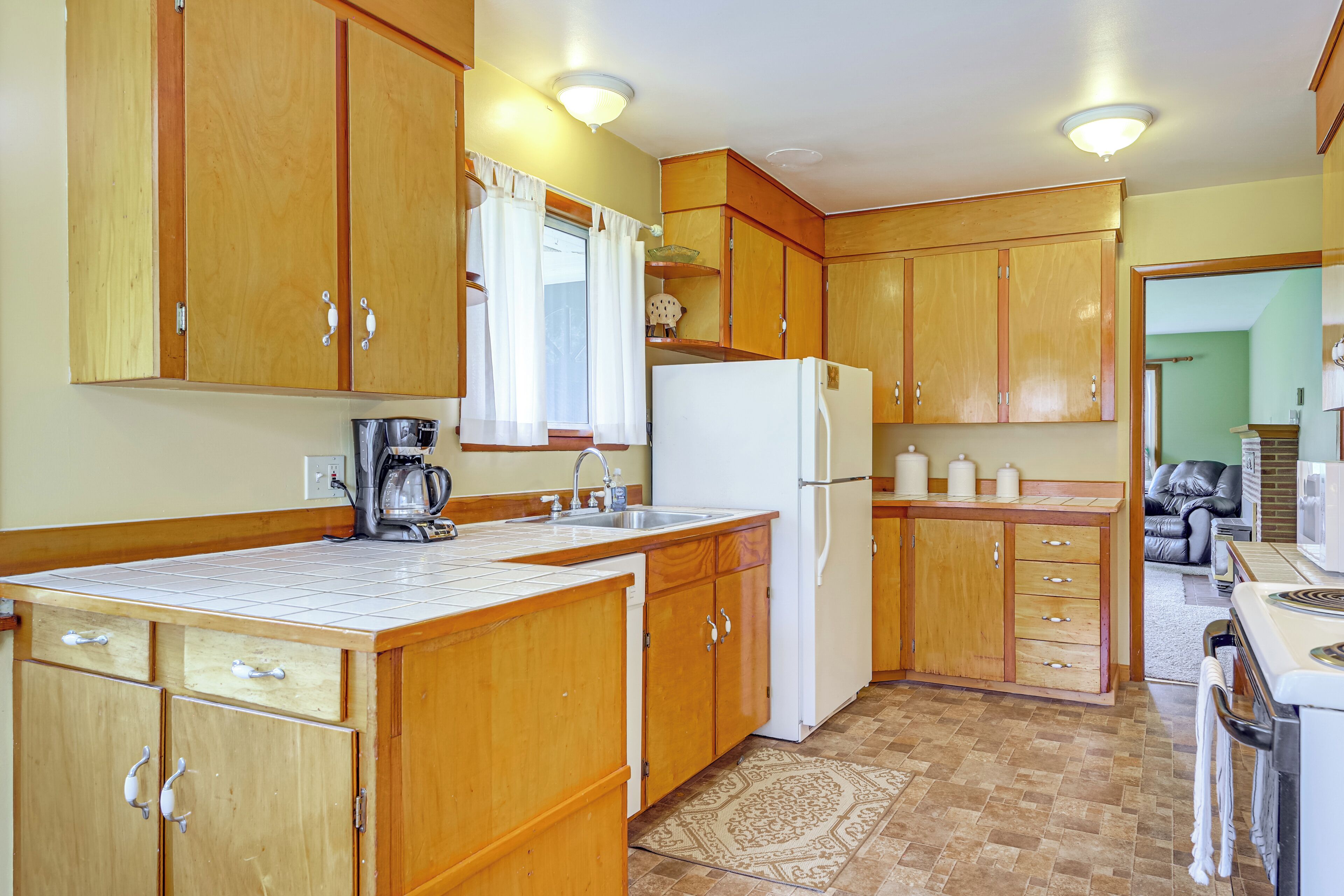 Una cucina con mobili in legno, un frigorifero, un lavello e una macchina da caffè.