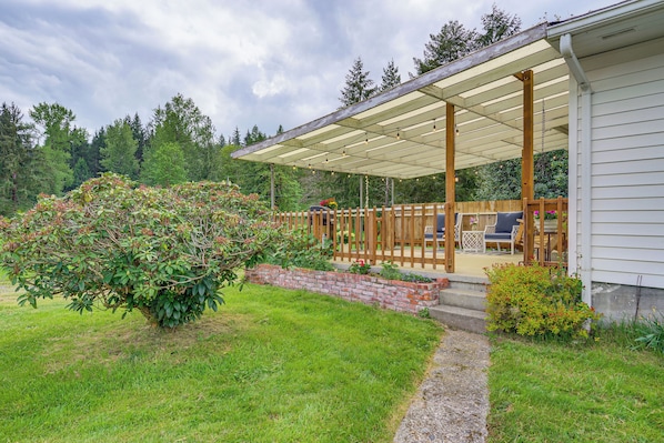 A covered patio with outdoor furniture, a brick planter, and a wooden fence. - Great for Families! Peaceful Snohomish Escape! (Snohomish)