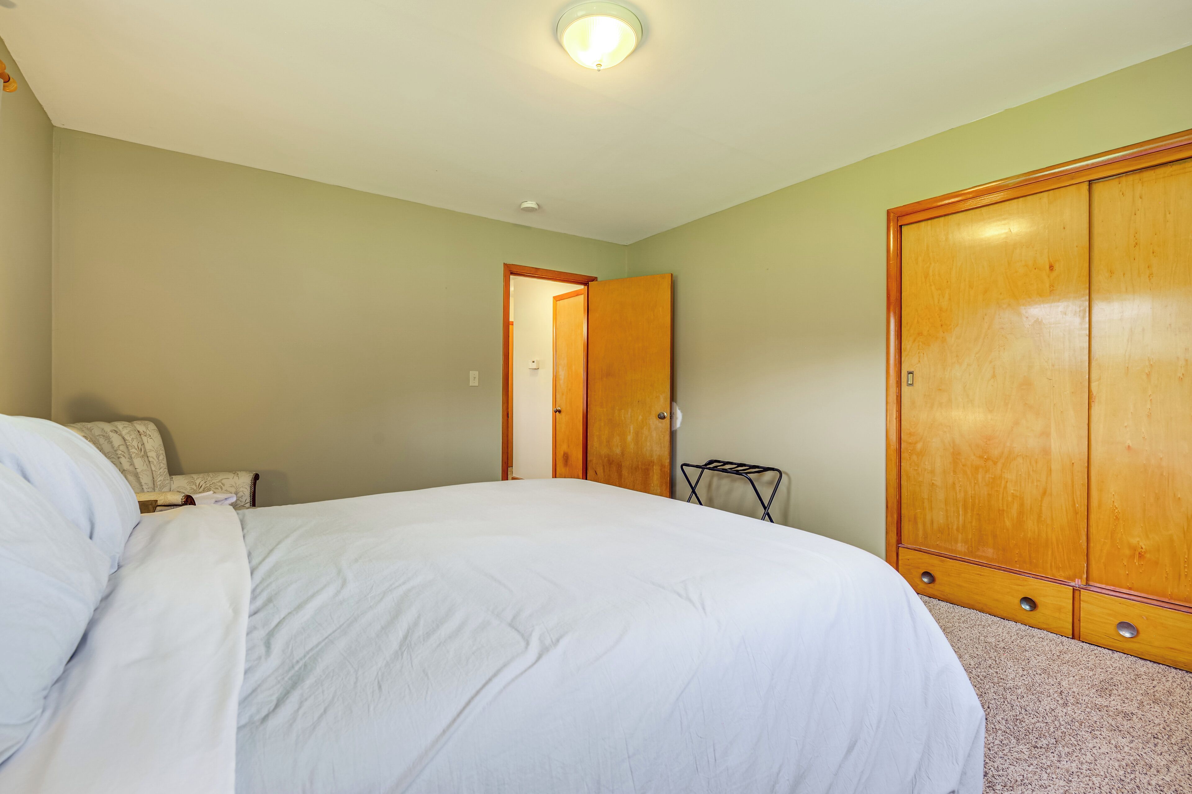 Une chambre à coucher avec un lit, une armoire et une chaise.
