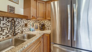 A kitchen with wooden cabinets, a stainless steel refrigerator, and a tiled backsplash. - Spacious Yard & Deck! Great Space in Munds Park (Munds Park)