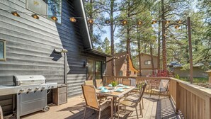 An outdoor deck with a grill, dining table, chairs, and string lights. - Spacious Yard & Deck! Great Space in Munds Park (Munds Park)