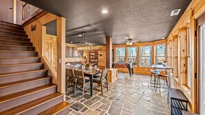 A wooden interior with a stone floor, a dining area, and a pool table. - Sleeps 14! Hot Tub*Resort Amenities*Arcade*Games (Gatlinburg)