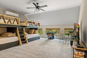 A room with bunk beds, a ceiling fan, a gaming console, and a window with a view. - Luxury Lakefront! 5BR*Lake Access*Hot Tub*Private! (Sevierville)