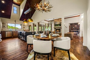 A spacious kitchen with a dining area, a fireplace, and a large window overlooking greenery. - Luxury Lakefront! 5BR*Lake Access*Hot Tub*Private! (Sevierville)