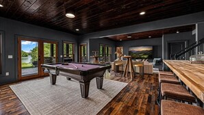 A modern interior with a pool table, bar area, and a scenic view through large windows. - Luxury Lakefront! 5BR*Lake Access*Hot Tub*Private! (Sevierville)