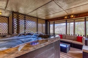 A hot tub with a wooden exterior, a wooden deck, and a seating area with cushions. - Peaceful 4BR w/Hot Tub*Theater*Views*Resort Access (Gatlinburg)