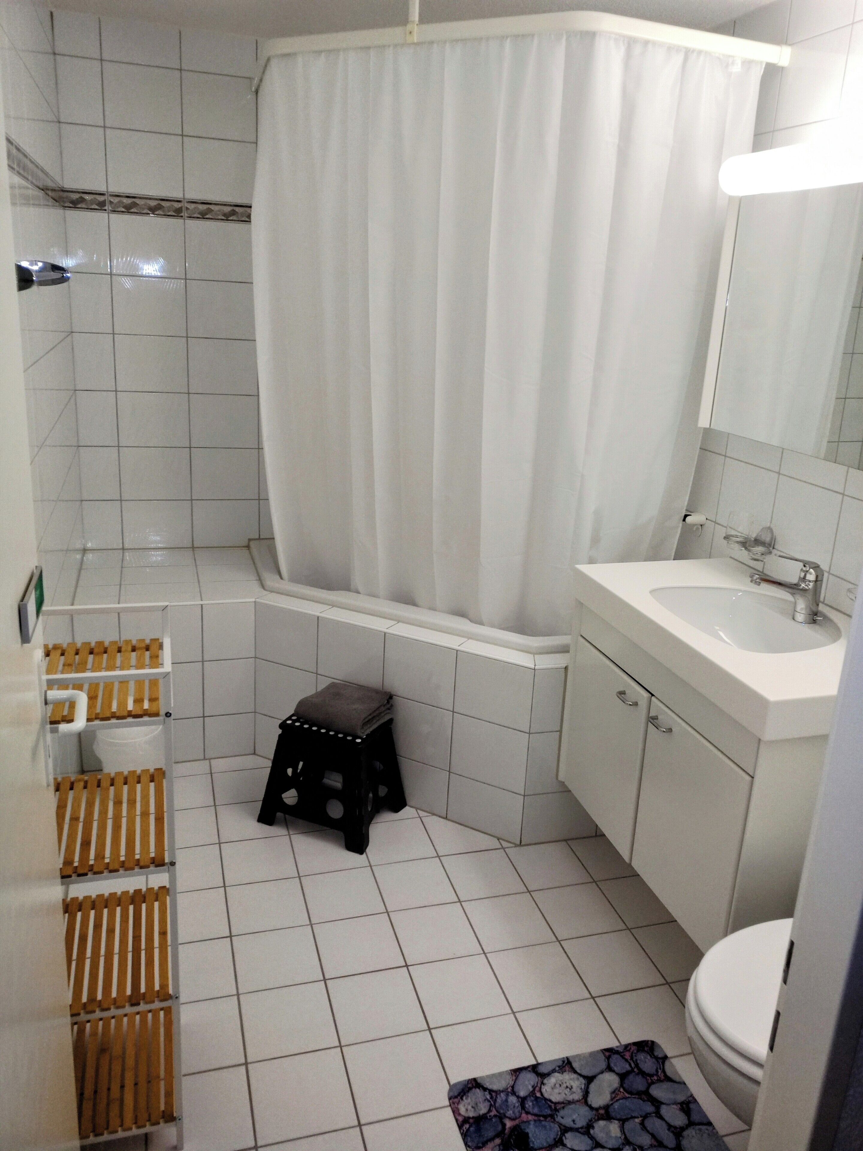 A bathroom with a bathtub, a sink, a toilet, and a shower curtain.