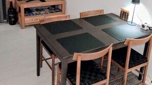 En matplats med ett bord, stolar, en tv och en lampa.