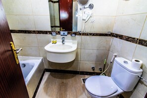 Un baño con lavamanos, inodoro y bañera.