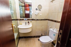 Tweepersoonskamer | Badkamer | Een douche, een haardroger, handdoeken, zeep