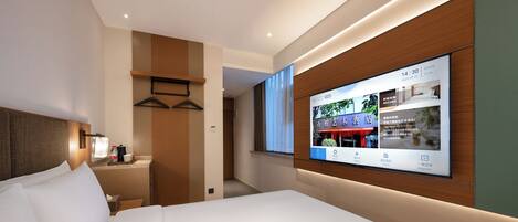A modern hotel room with a large bed, a bedside table with a lamp, a TV mounted on the wall, and a wooden panel design.