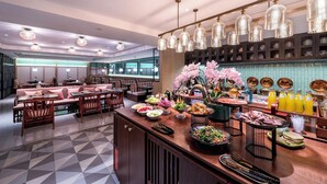 Ein modernes Restaurant mit einer zentralen Bar, Sitzgelegenheiten und einer dekorativen Orchideen-Ausstellung.
