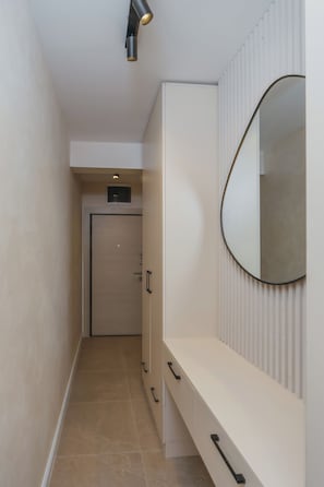 A hallway with a wardrobe, a mirror, and a door.