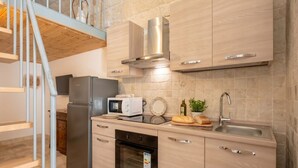 Une cuisine moderne dotée d’appareils électroménagers en acier inoxydable, d’un four encastré et d’un plan de travail en bois.