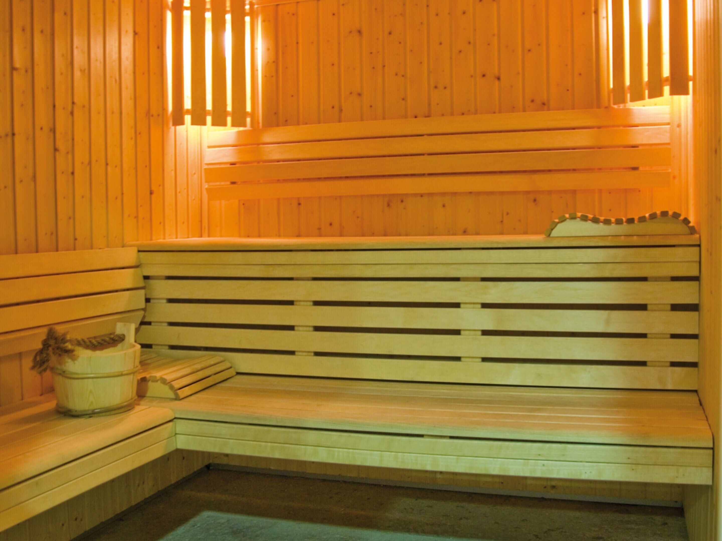 En träbeklädd bastu med sittbänkar och en sittplats.