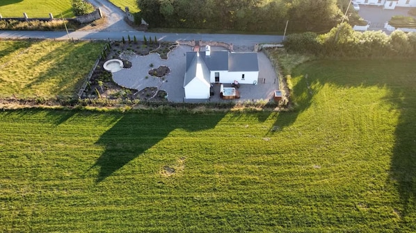 Une maison avec une grande allée, un jacuzzi et une pelouse bien entretenue.
