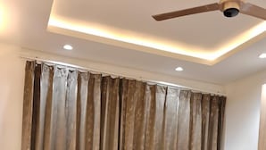 A ceiling fan, recessed lighting, and a curtain. - ATITHI (Hisar)
