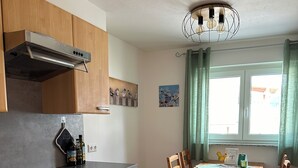 Una cucina con mobili in legno, un fornello e un tavolo da pranzo con sedie.