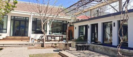 A modern house with large windows, a patio, and a pergola.
