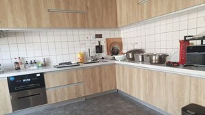A modern kitchen with wooden cabinets, a dishwasher, a stove, and a toaster.