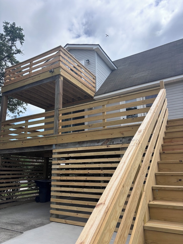 A multi-level wooden deck with a staircase leading to a covered area.
