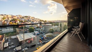 A balcony with a view of a cityscape, including buildings and a gas station. - Benesta Centro by GOLDFINCH (Istanbul)