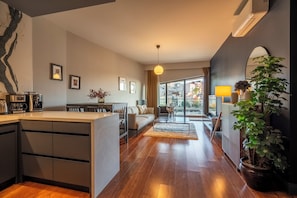 Una cocina moderna con zona de comedor, sofá y un amplio ventanal con vistas a la ciudad.