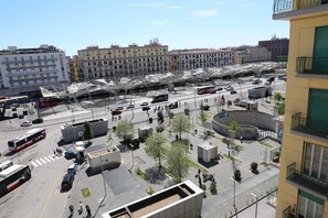 A busy urban street with multiple lanes, a bus, and pedestrians. - Tangueu Suites & Rooms (Naples)