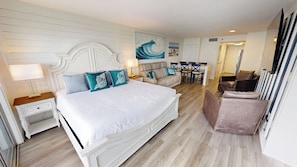 A bedroom with a large bed, a sofa, a dining table, and a chair. - New Luxurious 1 BR/2 Ba with 2 Kings and a Queen w/ Free Beach Service for 4! (Fort Walton Beach)