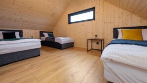 Quarto com duas camas, uma mesa pequena e uma janela.