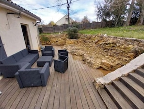 Eine Terrasse mit Gartenmöbeln und einer Steinmauer.