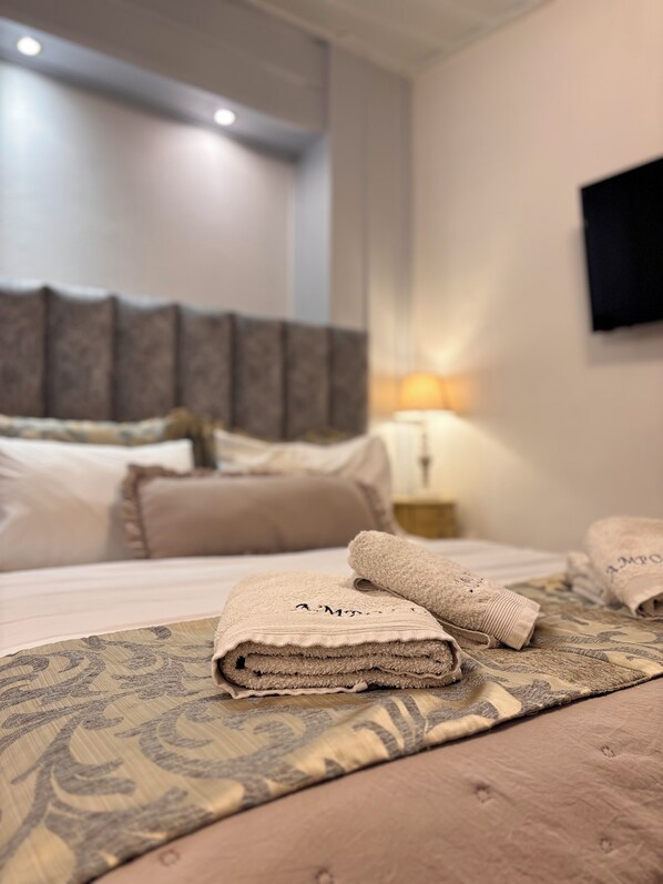 A neatly made bed with a patterned bedspread, a bedside lamp, and a headboard with decorative elements.
