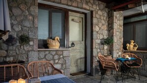 Un edificio in pietra con facciata rustica, mobili in vimini e un tavolo con candele.