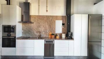 Una cocina moderna con electrodomésticos integrados, lavavajillas y refrigerador.