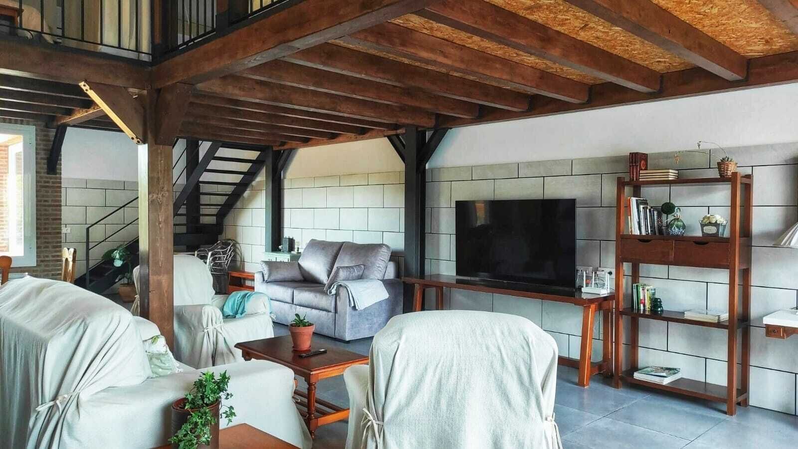 Una sala de estar con chimenea, televisión y estantería.